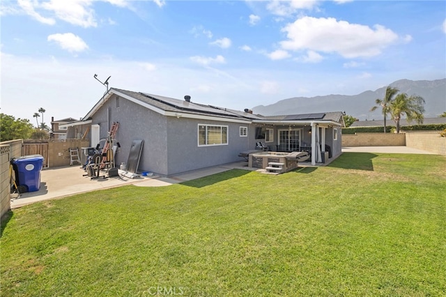6963 Shamrock Ln, Rancho Cucamonga, CA 91701 - rear view of property featuring a patio area, a hot tub, a fenced backyard, roof mounted solar panels, and a mountain view
