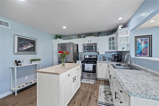 6963 Shamrock Ln, Rancho Cucamonga, CA 91701 - kitchen featuring appliances with stainless steel finishes, wood finished floors, open shelves, light countertops, and recessed lighting