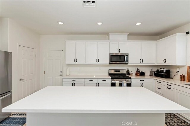 21288 Telegraph Rd, Riverside, CA 92507 - kitchen featuring stainless steel appliances, light countertops, white cabinets, a kitchen island, and recessed lighting