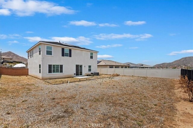 21288 Telegraph Rd, Riverside, CA 92507 - back of house featuring a fenced backyard, stucco siding, roof mounted solar panels, and a mountain view