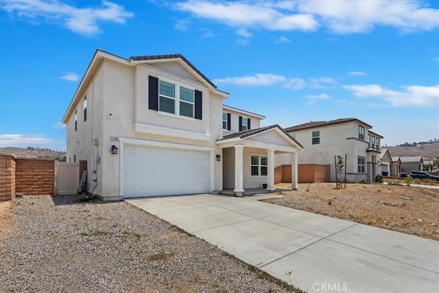 21288 Telegraph Rd, Riverside, CA 92507 - traditional home featuring stucco siding, an attached garage, a porch, and driveway