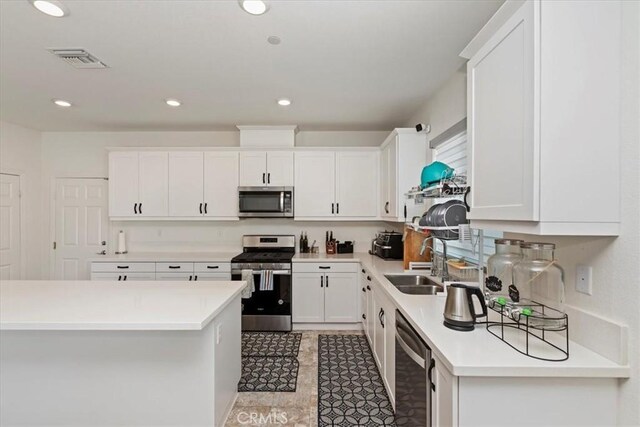 21288 Telegraph Rd, Riverside, CA 92507 - kitchen featuring appliances with stainless steel finishes, light countertops, white cabinets, recessed lighting, and light tile patterned floors