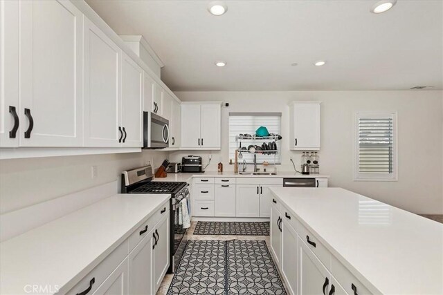 21288 Telegraph Rd, Riverside, CA 92507 - kitchen with appliances with stainless steel finishes, light countertops, white cabinetry, and recessed lighting