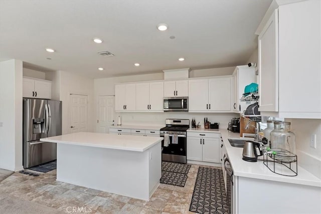 21288 Telegraph Rd, Riverside, CA 92507 - kitchen featuring appliances with stainless steel finishes, a kitchen island, light countertops, white cabinets, and recessed lighting