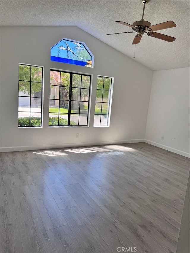 26226 Rainbow Glen Dr, Newhall, CA 91321 - empty room featuring vaulted ceiling, a ceiling fan, wood finished floors, and a textured ceiling