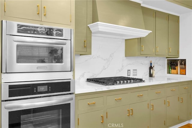 929 E Marshall Pl, Long Beach, CA 90807 - kitchen with appliances with stainless steel finishes, custom exhaust hood, light countertops, tasteful backsplash, and green cabinets