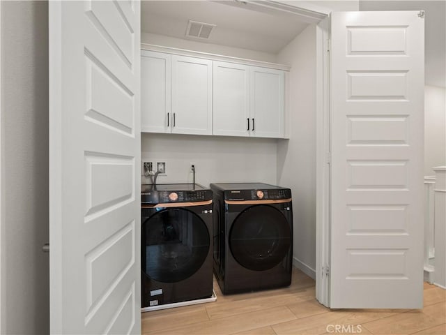 27148 Valley Oak Pl, Valencia, CA 91381 - laundry room featuring washing machine and clothes dryer, light wood-style flooring, and cabinet space