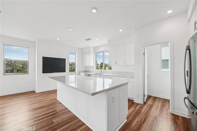 301 Placemark, Irvine, CA 92614 - kitchen featuring a kitchen island, wood finished floors, white cabinets, light countertops, and freestanding refrigerator