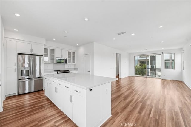 301 Placemark, Irvine, CA 92614 - kitchen featuring stainless steel appliances, a kitchen island, recessed lighting, light wood-type flooring, and white cabinets