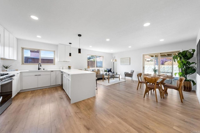 9121 Heatherdale St, Santee, CA 92071 - kitchen with stainless steel range, a peninsula, light wood-style floors, plenty of natural light, and recessed lighting