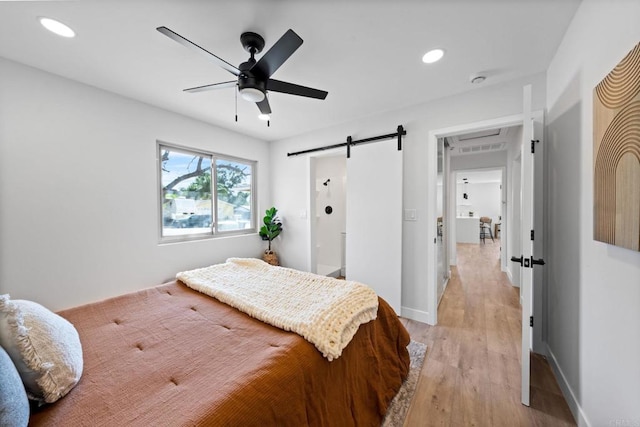 9121 Heatherdale St, Santee, CA 92071 - bedroom with a barn door, light wood finished floors, recessed lighting, and ceiling fan