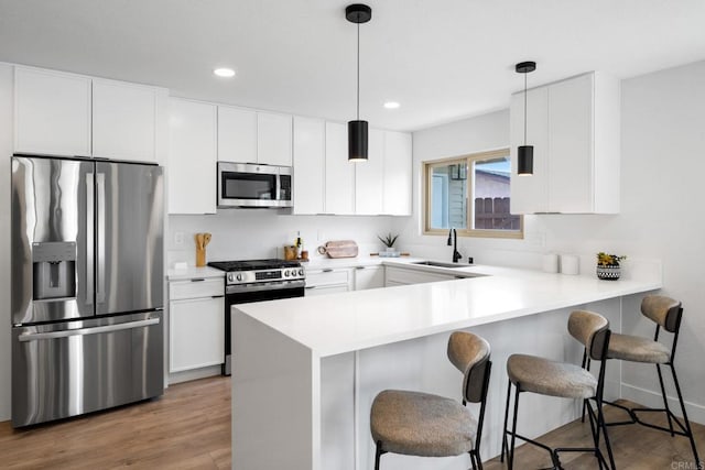 9121 Heatherdale St, Santee, CA 92071 - kitchen featuring stainless steel appliances, a peninsula, a breakfast bar, white cabinetry, and recessed lighting