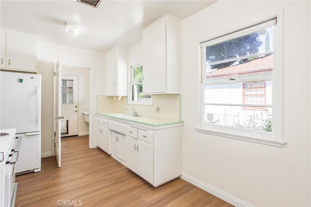 722 E 19th St, San Bernardino, CA 92404 - kitchen featuring light countertops, light wood-style floors, white cabinetry, white appliances, and backsplash