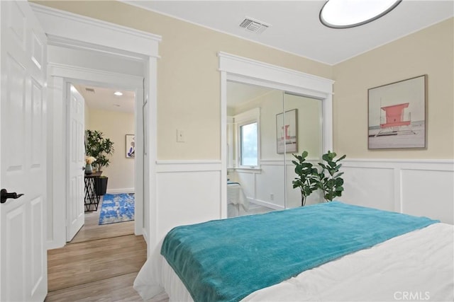 4841 E Los Coyotes Diagonal, Long Beach, CA 90815 - bedroom featuring wood finished floors, wainscoting, and a decorative wall