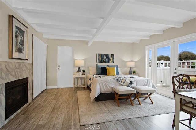 4841 E Los Coyotes Diagonal, Long Beach, CA 90815 - bedroom featuring wood finished floors, access to outside, beamed ceiling, and a fireplace
