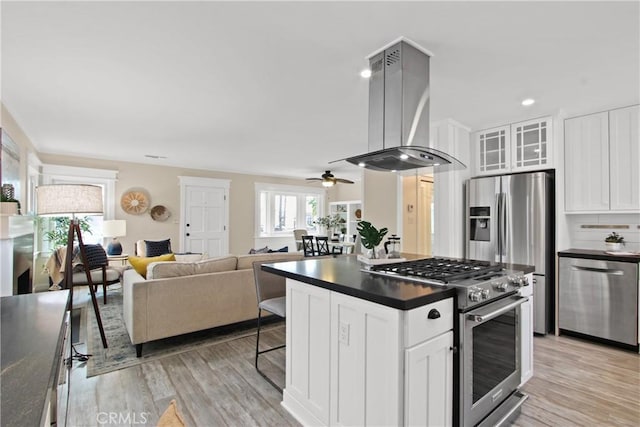 4841 E Los Coyotes Diagonal, Long Beach, CA 90815 - kitchen with appliances with stainless steel finishes, island range hood, dark countertops, light wood-type flooring, and white cabinetry