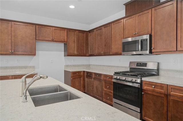 1649 Spring Run Ln, Beaumont, CA 92223 - kitchen with stainless steel appliances, recessed lighting, brown cabinetry, and light stone counters