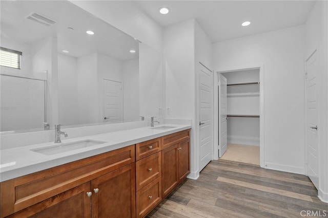 1649 Spring Run Ln, Beaumont, CA 92223 - full bathroom featuring double vanity, wood finished floors, recessed lighting, a walk in closet, and a shower