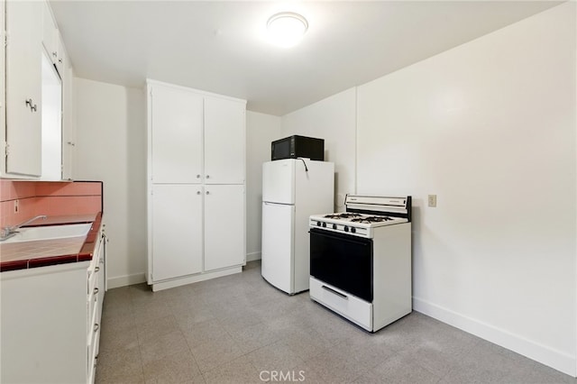 2723 57th St, Sacramento, CA 95817 - kitchen featuring white appliances, tile counters, white cabinets, light floors, and backsplash