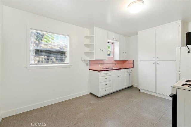 2723 57th St, Sacramento, CA 95817 - kitchen with range with gas cooktop, freestanding refrigerator, open shelves, white cabinets, and dark countertops
