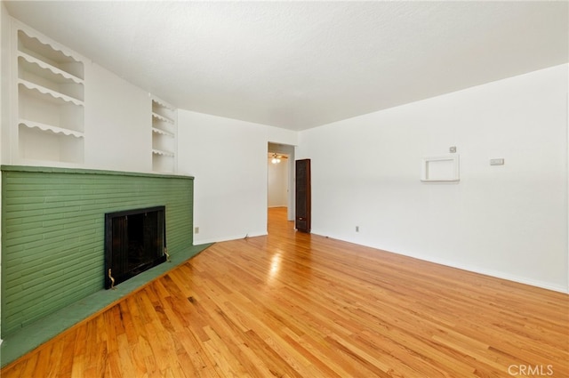 2723 57th St, Sacramento, CA 95817 - unfurnished living room featuring light wood-style flooring, a fireplace, and built in shelves