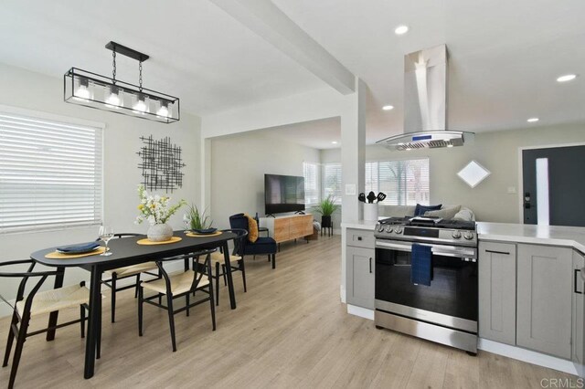 6127 Winchester St, San Diego, CA 92139 - kitchen featuring stainless steel gas stove, island exhaust hood, light countertops, light wood-style floors, and gray cabinets