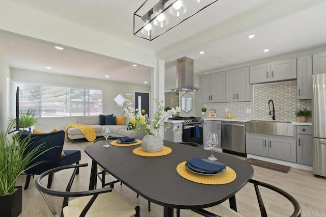6127 Winchester St, San Diego, CA 92139 - kitchen featuring island range hood, stainless steel appliances, gray cabinetry, decorative backsplash, and recessed lighting
