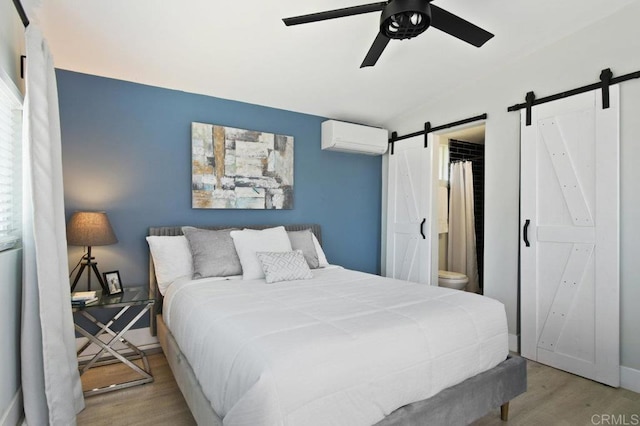 6127 Winchester St, San Diego, CA 92139 - bedroom featuring a barn door, a wall mounted AC, wood finished floors, vaulted ceiling, and ceiling fan