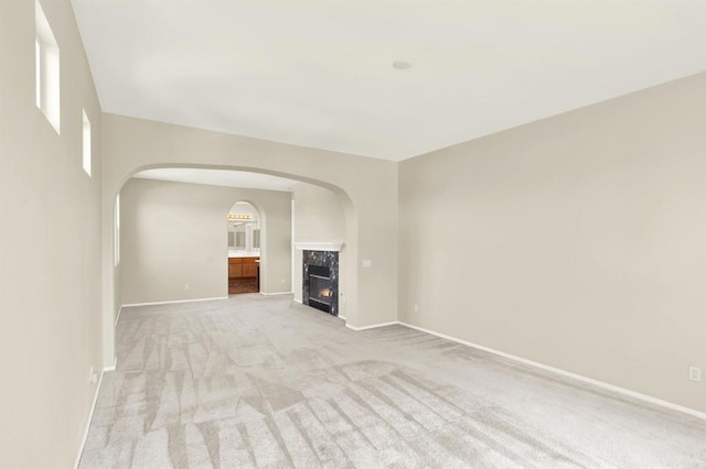 43883 Brookhaven Ct, Temecula, CA 92592 - unfurnished living room featuring arched walkways, light carpet, and a high end fireplace