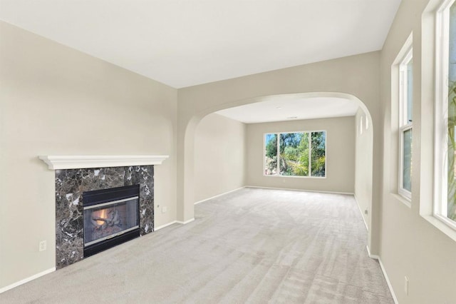 43883 Brookhaven Ct, Temecula, CA 92592 - unfurnished living room featuring carpet flooring, arched walkways, and a fireplace
