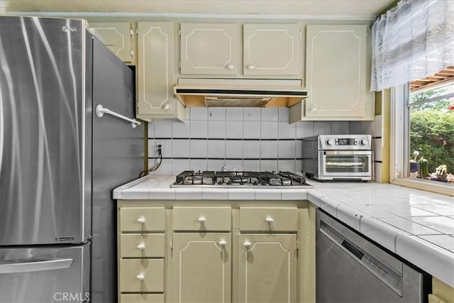 2374 Corydon Ave, Norco, CA 92860 - kitchen featuring appliances with stainless steel finishes, under cabinet range hood, tile countertops, and backsplash