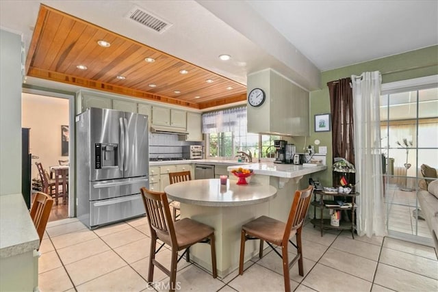 2374 Corydon Ave, Norco, CA 92860 - kitchen with stainless steel appliances, a peninsula, light countertops, light tile patterned floors, and a breakfast bar