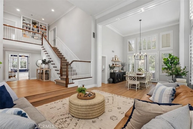 19256 Jasper Hill Rd, Lake Forest, CA 92679 - living room with a towering ceiling, a chandelier, wood finished floors, stairs, and crown molding