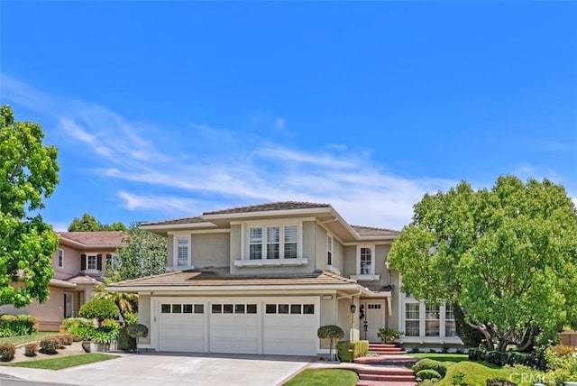 19256 Jasper Hill Rd, Lake Forest, CA 92679 - view of front facade featuring driveway, stucco siding, an attached garage, and a tiled roof