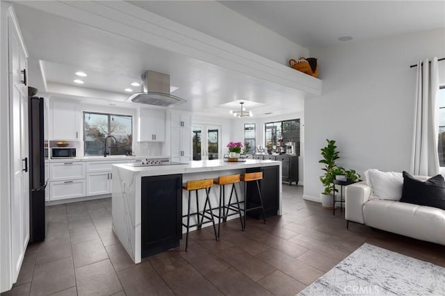 5027 Sleeping Indian Rd, Fallbrook, CA 92028 - kitchen featuring island exhaust hood, open floor plan, light countertops, a large island, and a kitchen bar