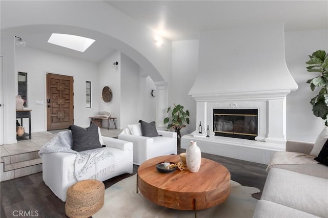 5027 Sleeping Indian Rd, Fallbrook, CA 92028 - living room featuring arched walkways, wood finished floors, vaulted ceiling, and a tiled fireplace