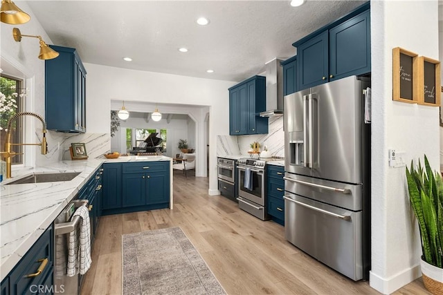 5825 Paseo De La Cumbre, Yorba Linda, CA 92887 - kitchen featuring appliances with stainless steel finishes, blue cabinets, wall chimney range hood, and recessed lighting