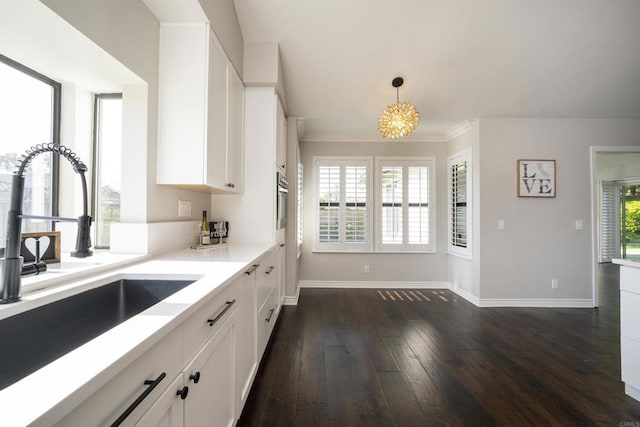 2044 Columbus Way, Vista, CA 92081 - kitchen with dark wood-style floors, white cabinets, light countertops, and crown molding