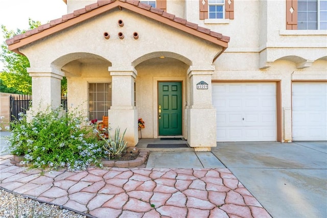 40209 Chelsea Ct, Palmdale, CA 93551 - view of exterior entry with driveway, an attached garage, stucco siding, and a tiled roof