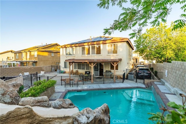 40209 Chelsea Ct, Palmdale, CA 93551 - rear view of property featuring a patio, roof mounted solar panels, a fenced backyard, stucco siding, and a gate