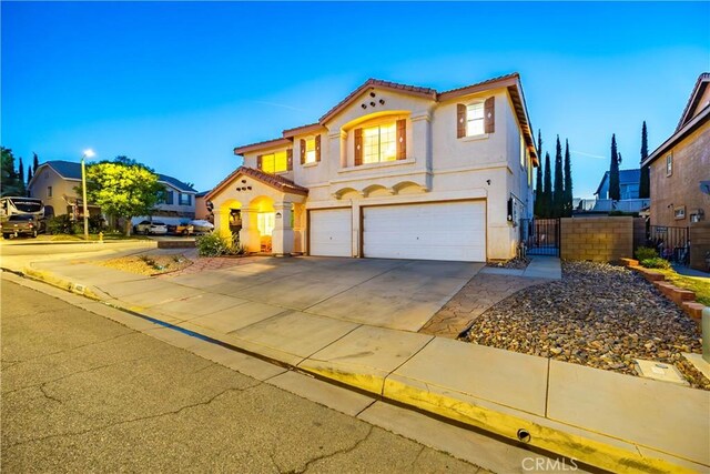 40209 Chelsea Ct, Palmdale, CA 93551 - mediterranean / spanish-style home featuring an attached garage, a tiled roof, stucco siding, driveway, and a gate