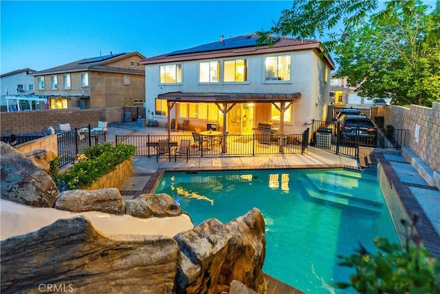 40209 Chelsea Ct, Palmdale, CA 93551 - rear view of house featuring solar panels, stucco siding, a fenced backyard, and a patio area