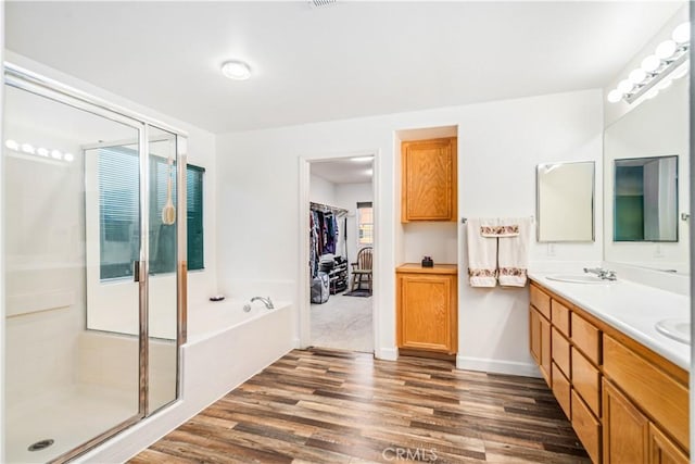 40209 Chelsea Ct, Palmdale, CA 93551 - full bathroom featuring double vanity, wood finished floors, a garden tub, a shower stall, and a walk in closet