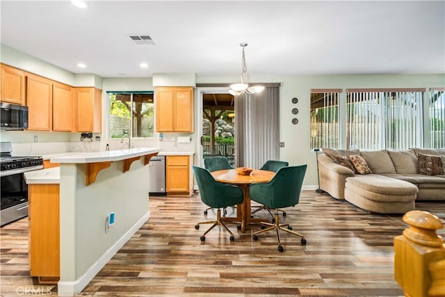40209 Chelsea Ct, Palmdale, CA 93551 - kitchen with appliances with stainless steel finishes, wood finished floors, light countertops, open floor plan, and recessed lighting