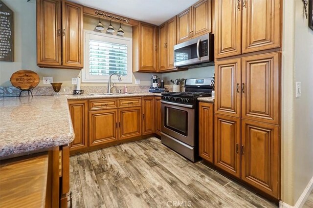 182 Darfo Dr, Crestline, CA 92325 - kitchen with appliances with stainless steel finishes, brown cabinets, and light wood-type flooring