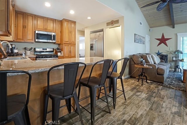 182 Darfo Dr, Crestline, CA 92325 - kitchen with stainless steel appliances, light stone counters, recessed lighting, a peninsula, and dark wood-style flooring