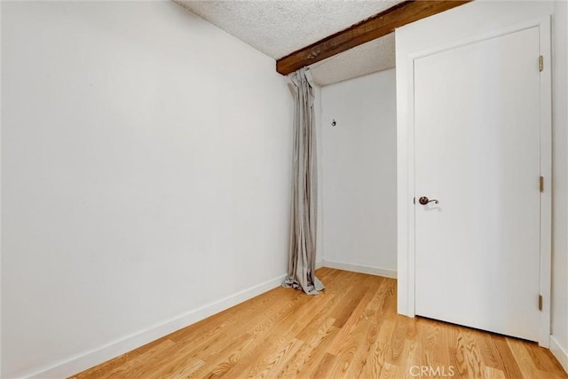 1701 Clinton St Unit 402, Los Angeles, CA 90026 - spare room featuring a textured ceiling, light wood finished floors, and beamed ceiling