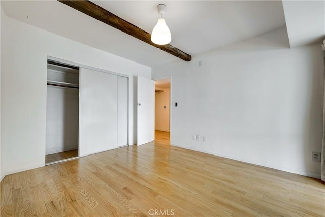 1701 Clinton St Unit 402, Los Angeles, CA 90026 - unfurnished bedroom with wood finished floors, beam ceiling, and a closet