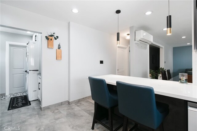 8527 Casaba Ave, Winnetka, CA 91306 - kitchen featuring stacked washer / drying machine, an AC wall unit, light countertops, pendant lighting, and recessed lighting