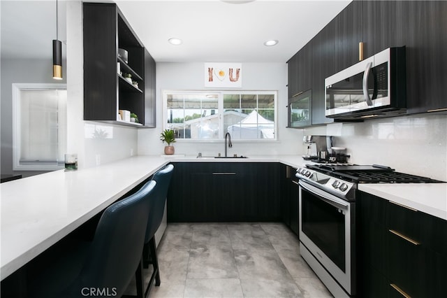 8527 Casaba Ave, Winnetka, CA 91306 - kitchen featuring appliances with stainless steel finishes, dark cabinetry, light countertops, modern cabinets, and open shelves